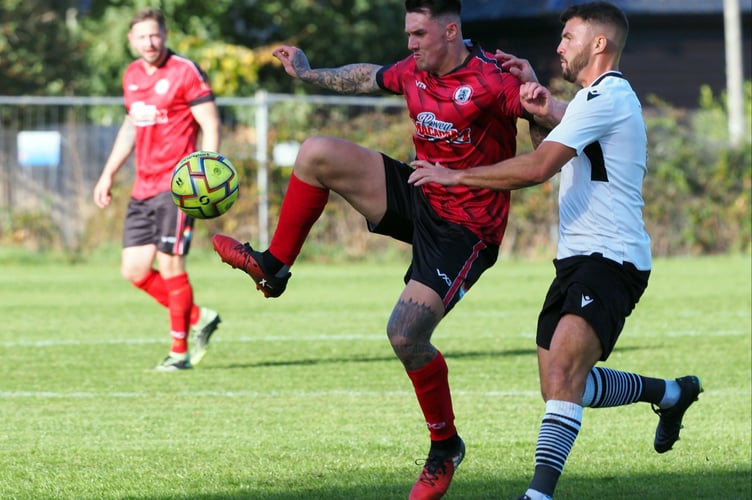 Bovey midfielder Brad Crocombe (middle) brings the ball under control.