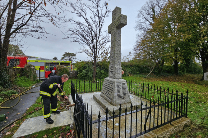 Buckfastleigh firefighters cleaning the town's war memorial ahead of Remembrance Sunday